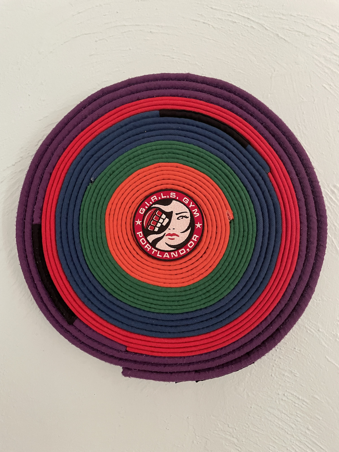 Brazilian jiu-jitsu belts Mom earned, arranged and displayed as art